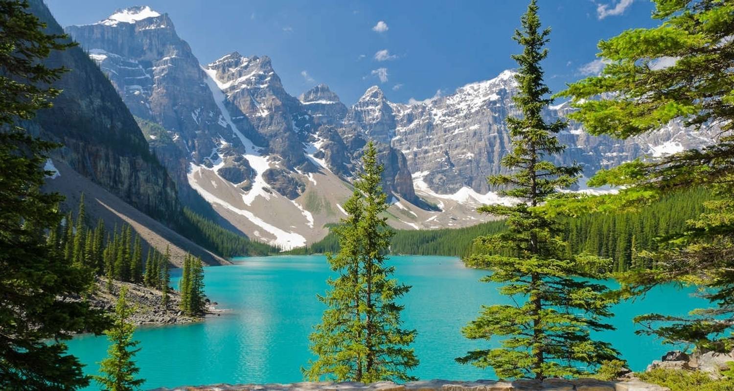 A turquoise lake surrounded by pine forests and mountains in the Canadian Rockies